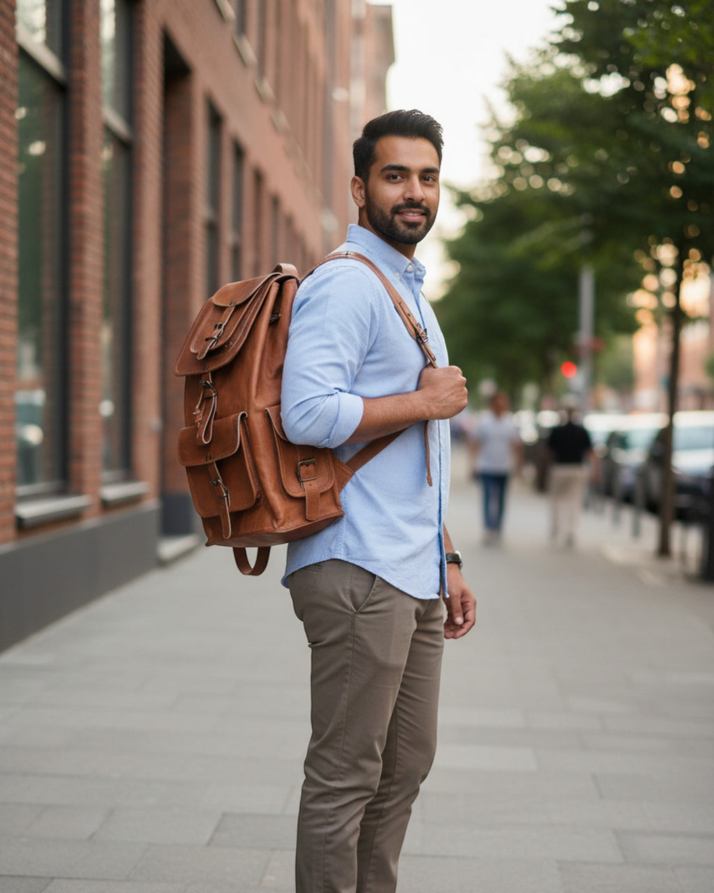 The Aravalli Backpack carried on a city street — tan leather multi-pocket rucksack