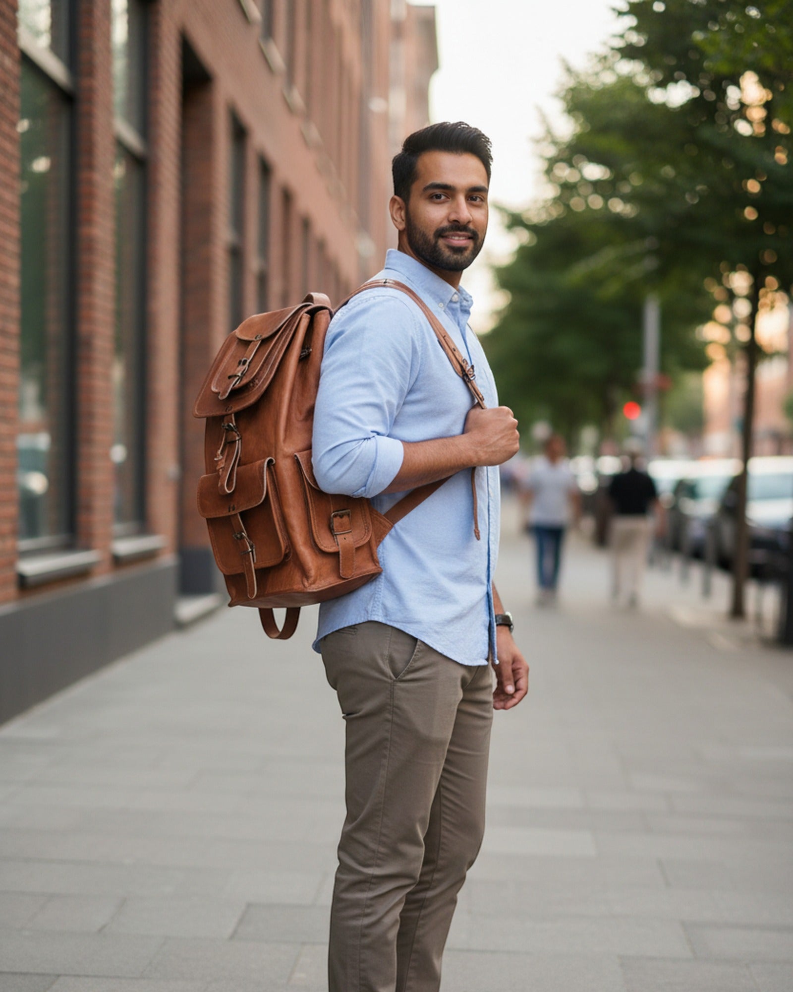 The Aravalli Backpack carried on a city street — tan leather multi-pocket rucksack