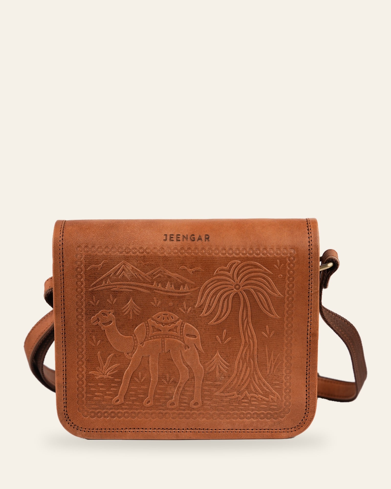 The Jaisalmer Sling in Tan — hand-embossed camel, palm and mountain scene with JEENGAR stamp, front view
