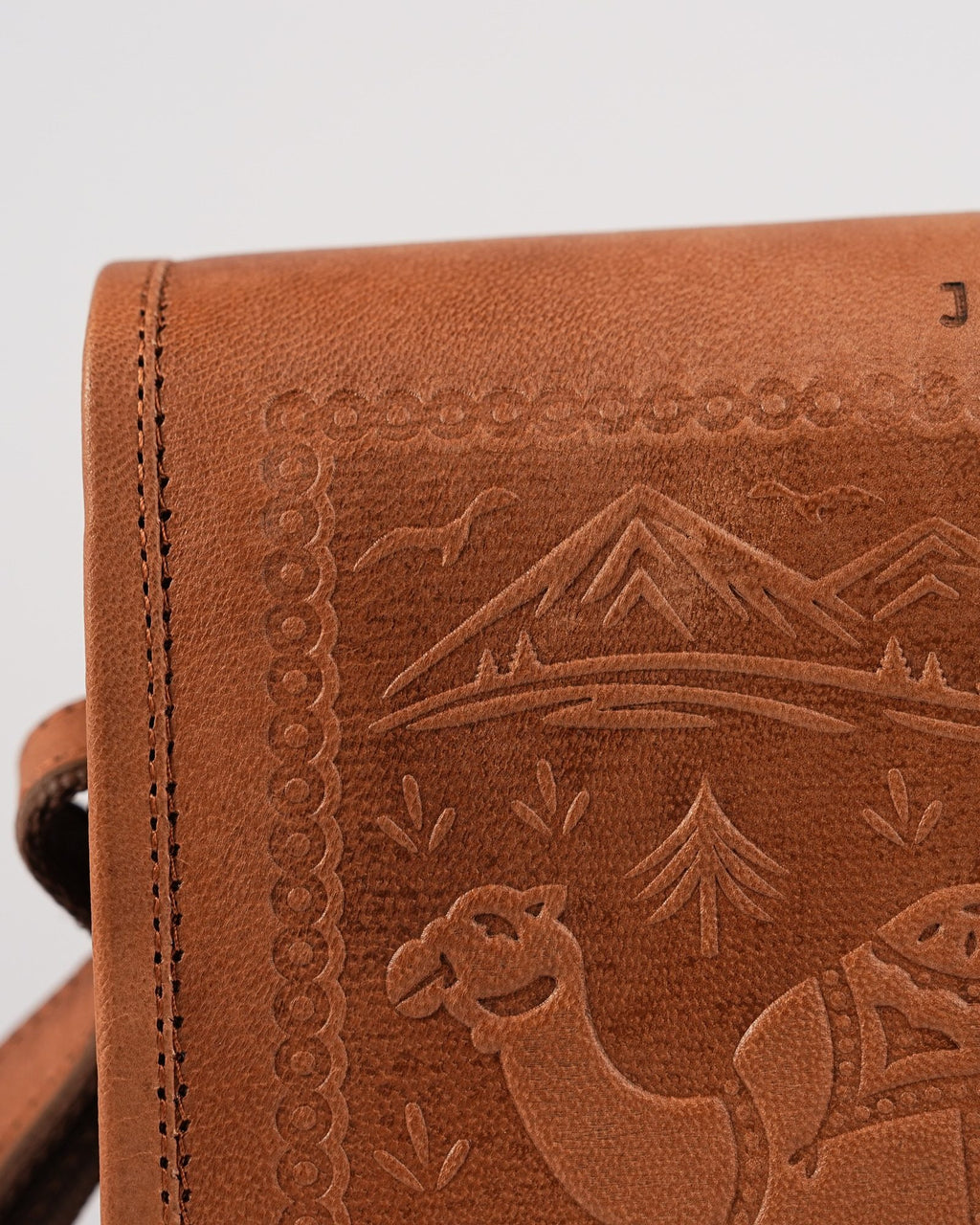 The Jaisalmer Sling in Tan — close detail of the embossed camel and palm motif