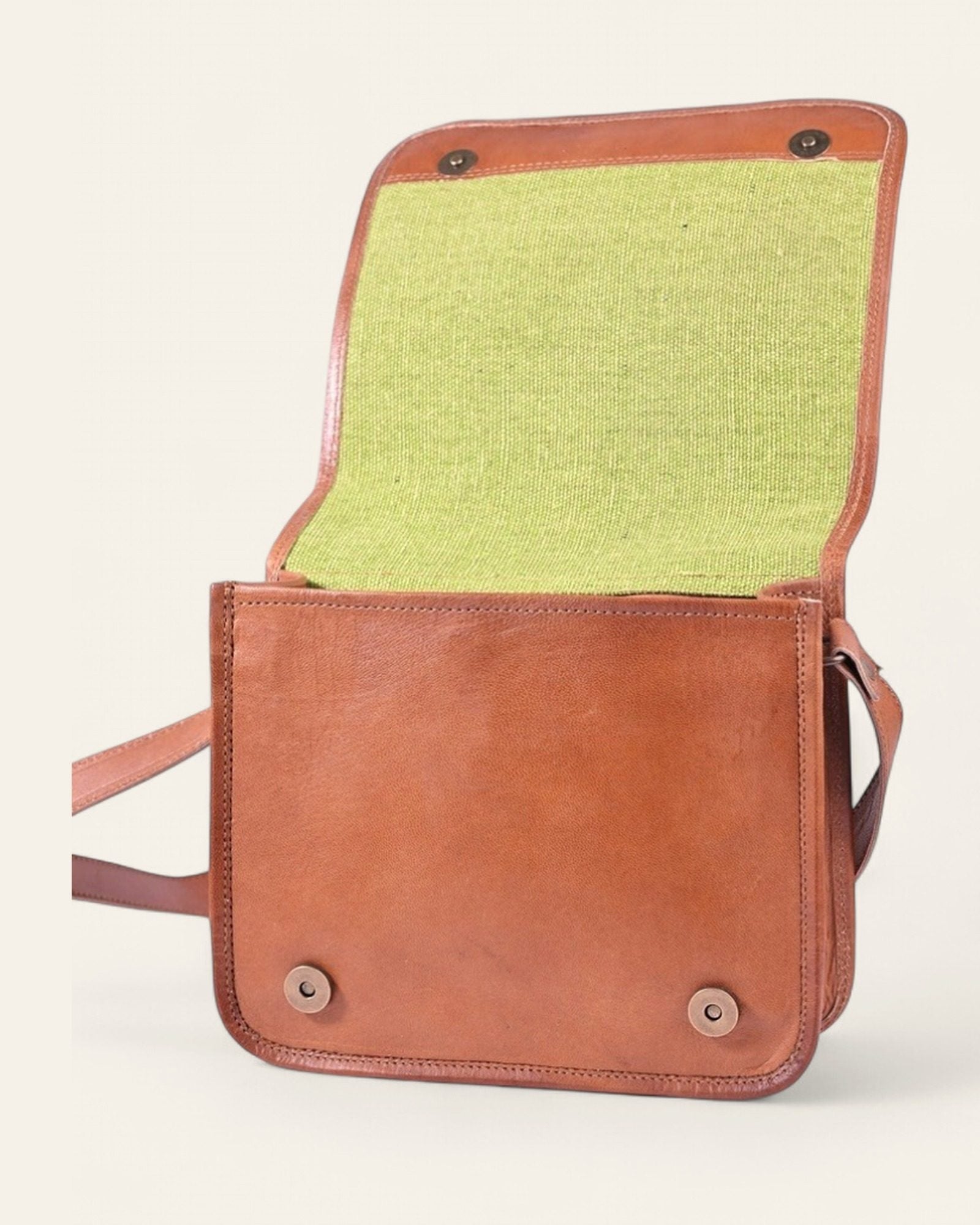The Mandore Sling — open flap showing the bright green canvas interior and snap closures