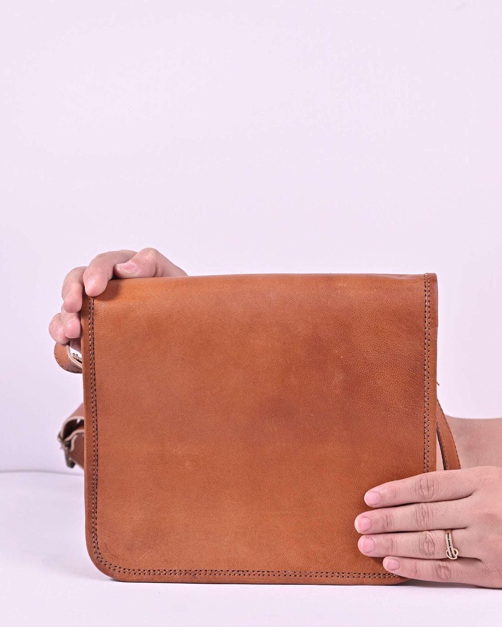 The Mandore Sling held in hands — compact everyday scale