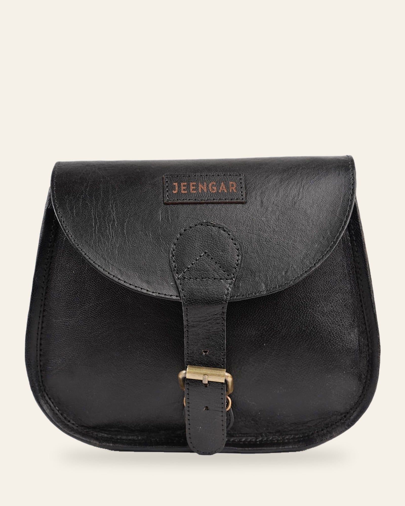 The Marwari Sling in Black — saddle-flap real leather sling with stitched Jeengar label, front view