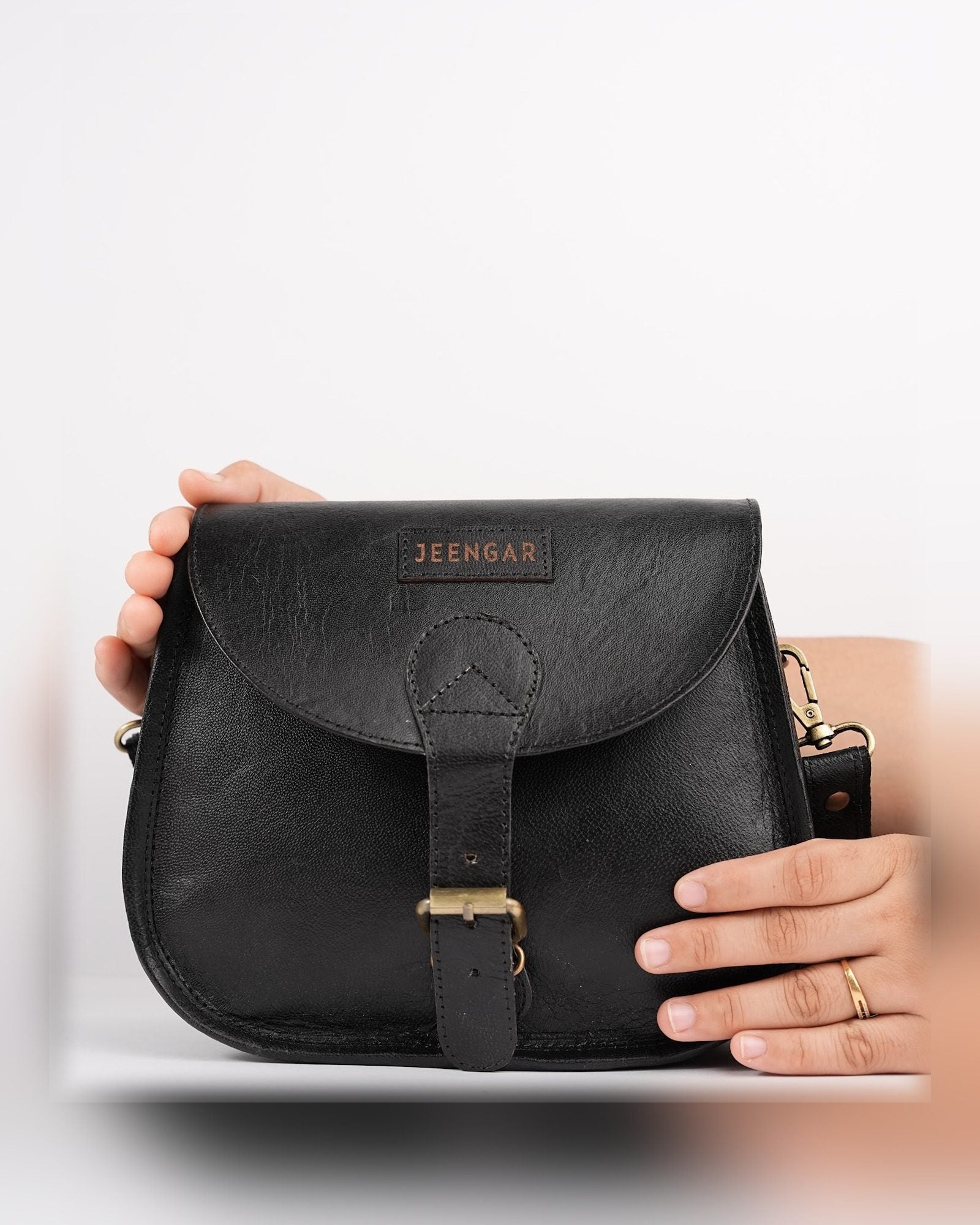 The Marwari Sling in Black held in hand — compact everyday scale