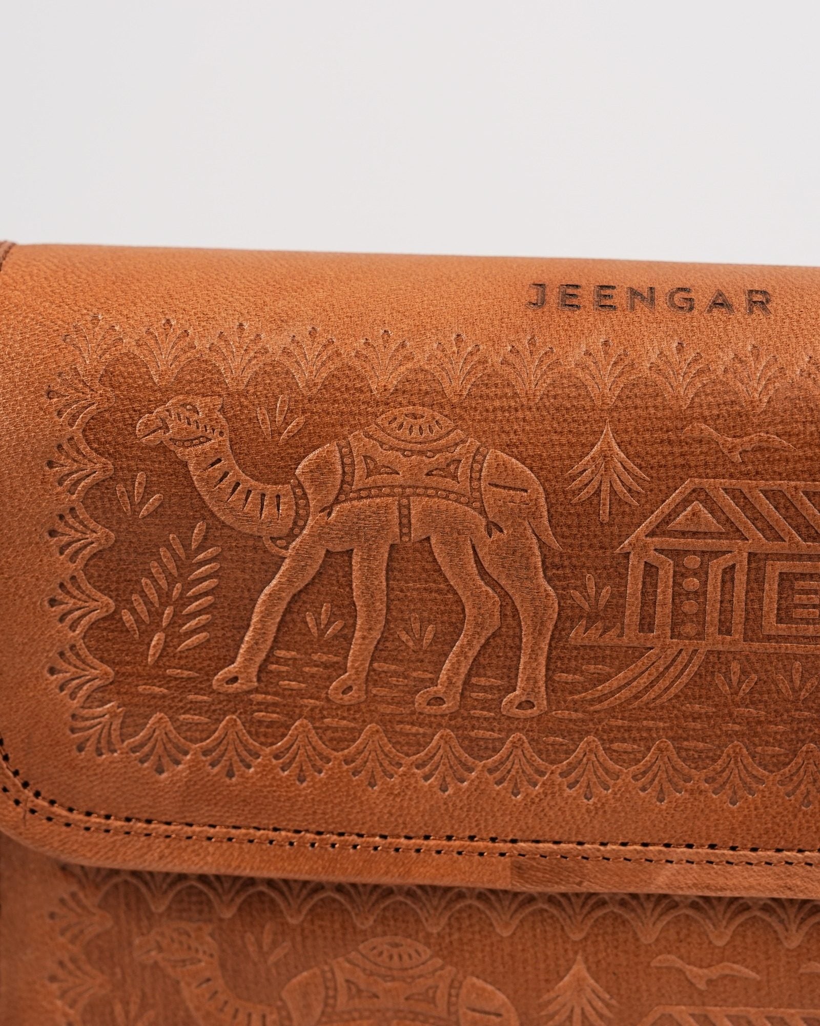The Pushkar Sling in Tan — close detail of the hand-embossed camel, dwelling and palm motif