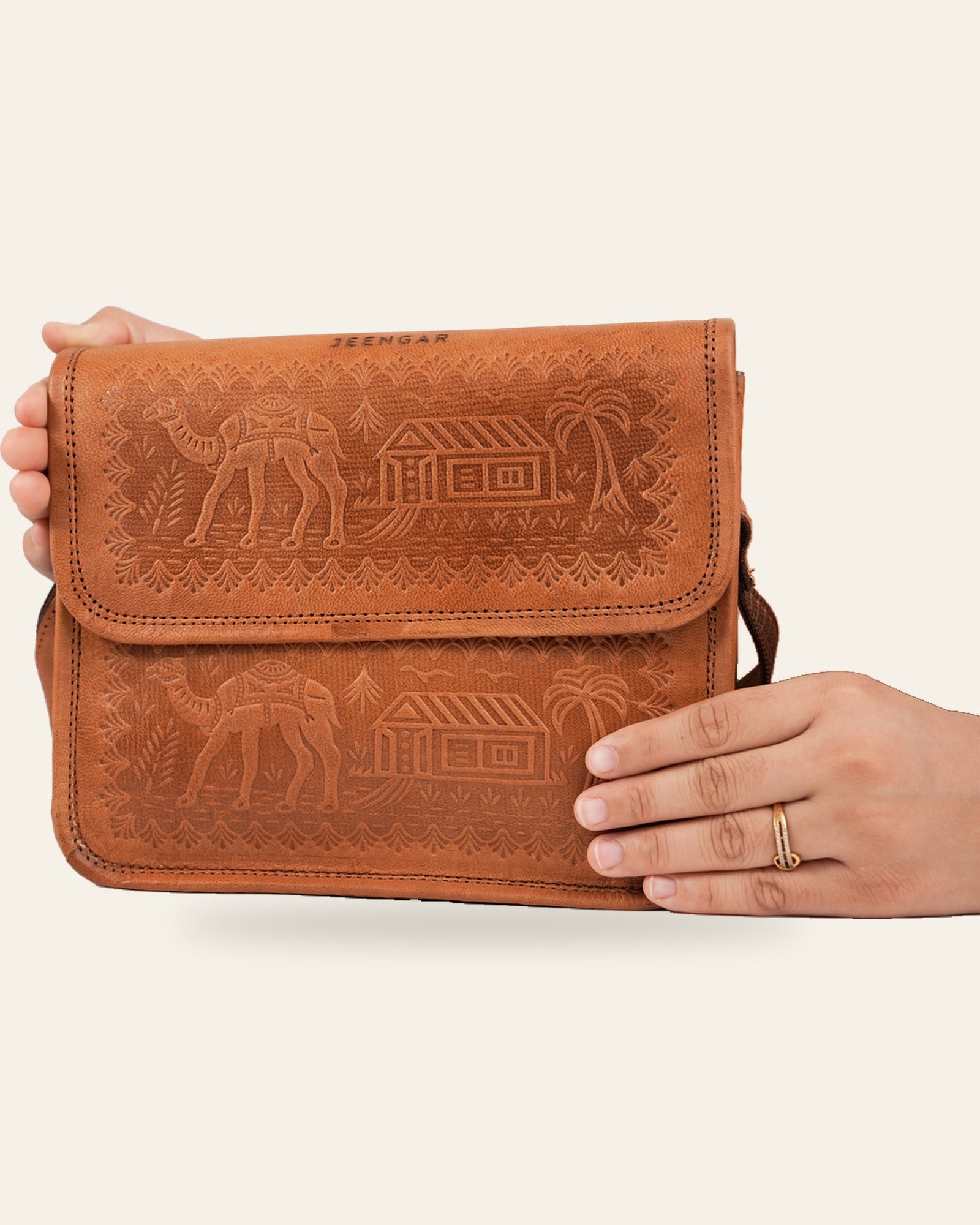 The Pushkar Sling in Tan held in hand — compact everyday scale