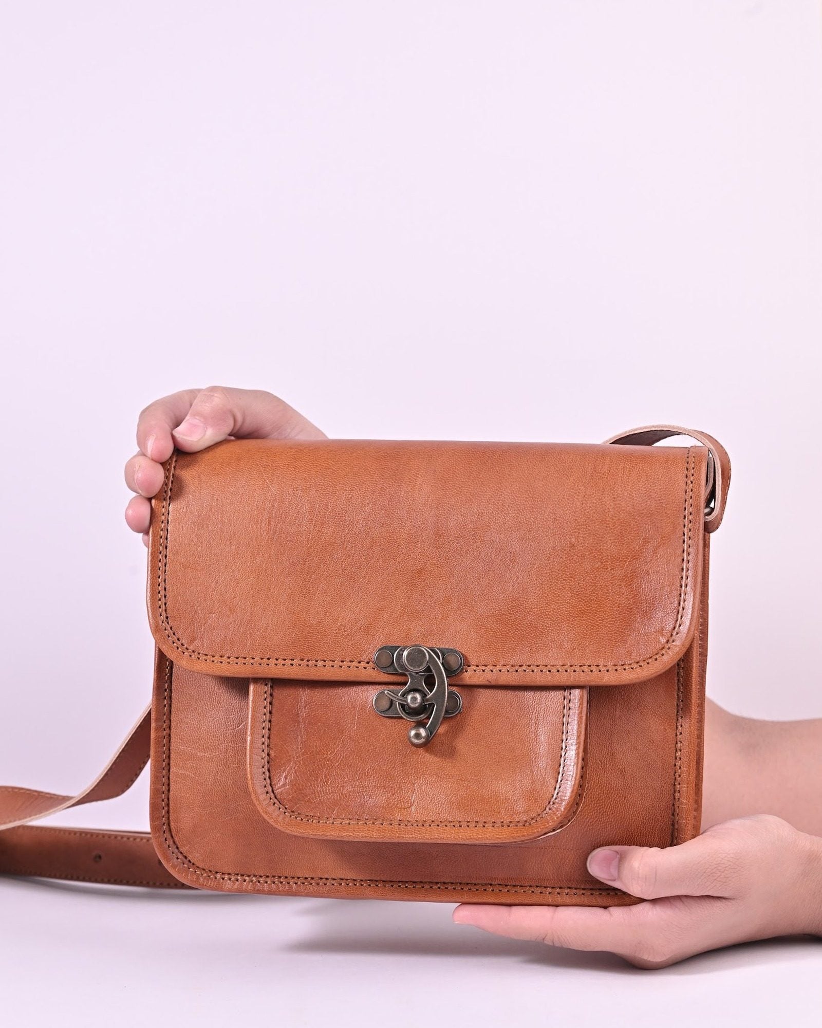 The Taragarh Satchel held in hands — compact everyday scale