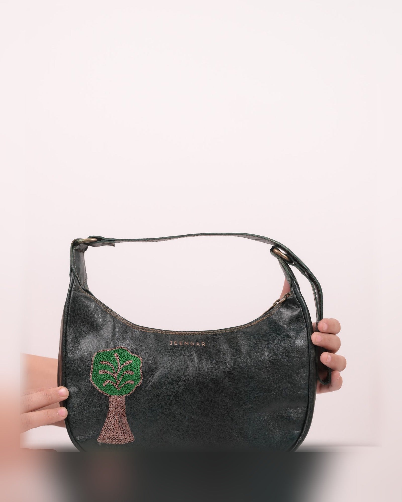 The Kashida Shoulder Bag Padmini in Dark Olive held in hand