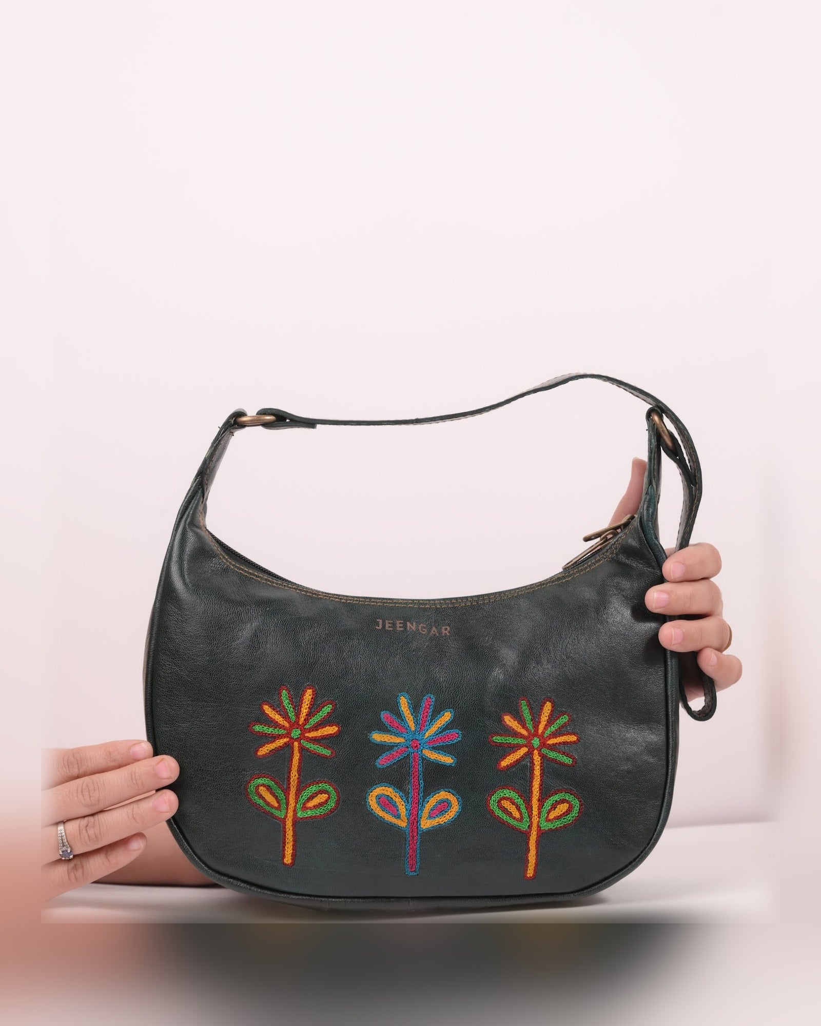 The Kashida Shoulder Bag Sanyogita in Dark Olive held in hand