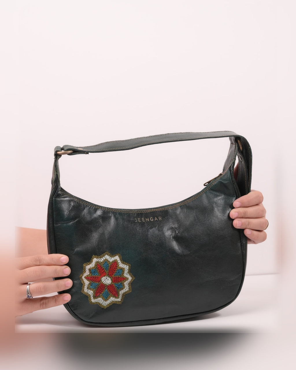 The Kashida Shoulder Bag Hadi in Dark Olive held in hand