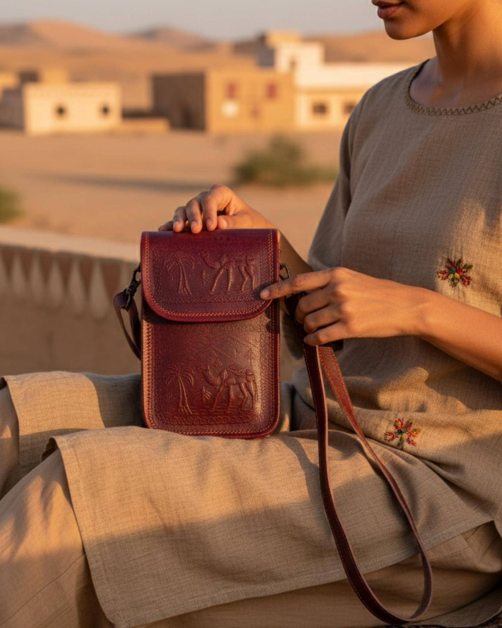 The Nagaur Sling in Cherry — embossed desert caravan motif on real leather
