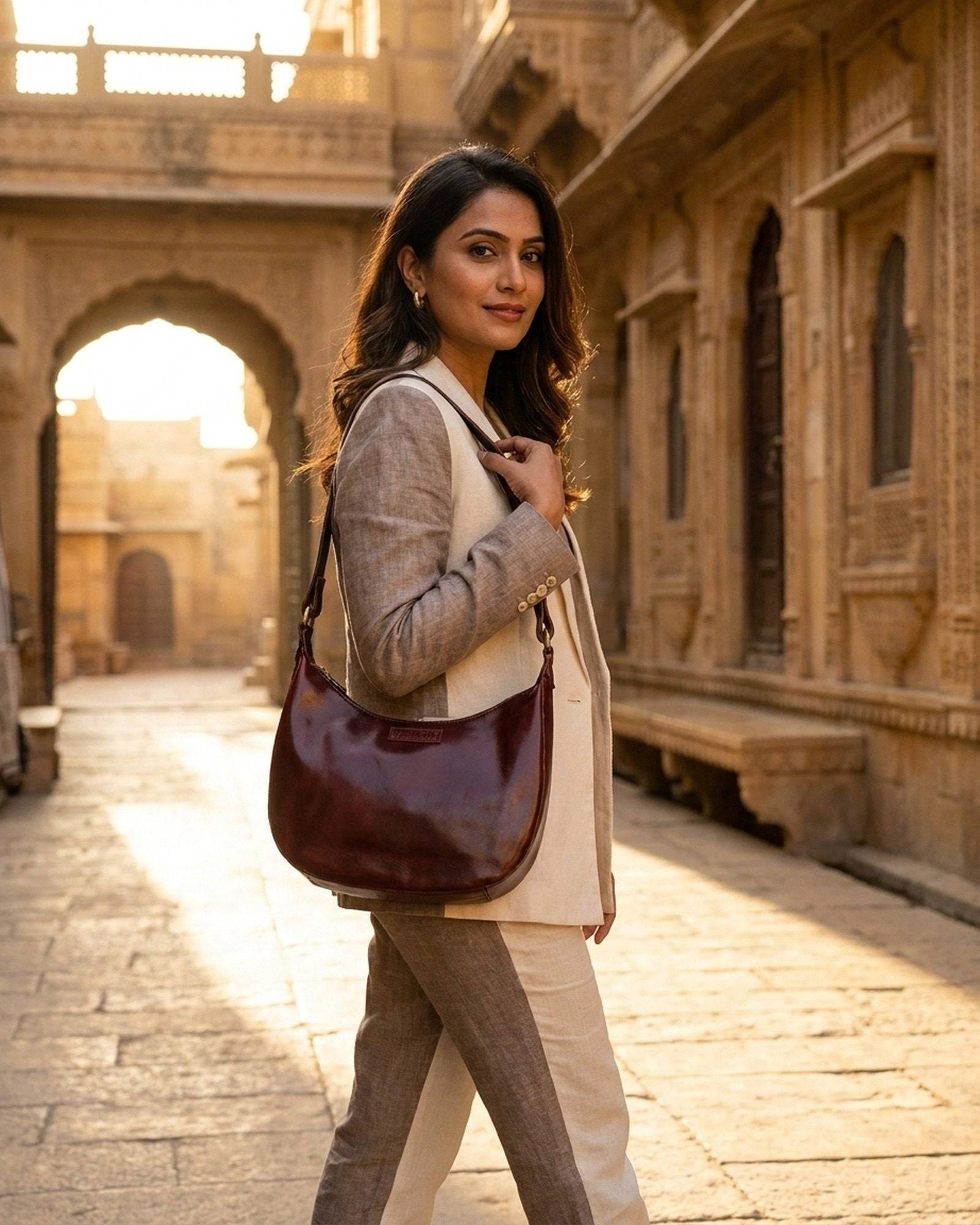 The Ranisar Shoulder Bag in Cherry worn on the shoulder on a Jaisalmer street