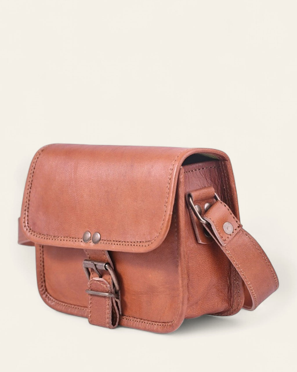 The Alwar Mini Satchel — angled view with antique-brass buckle and adjustable strap