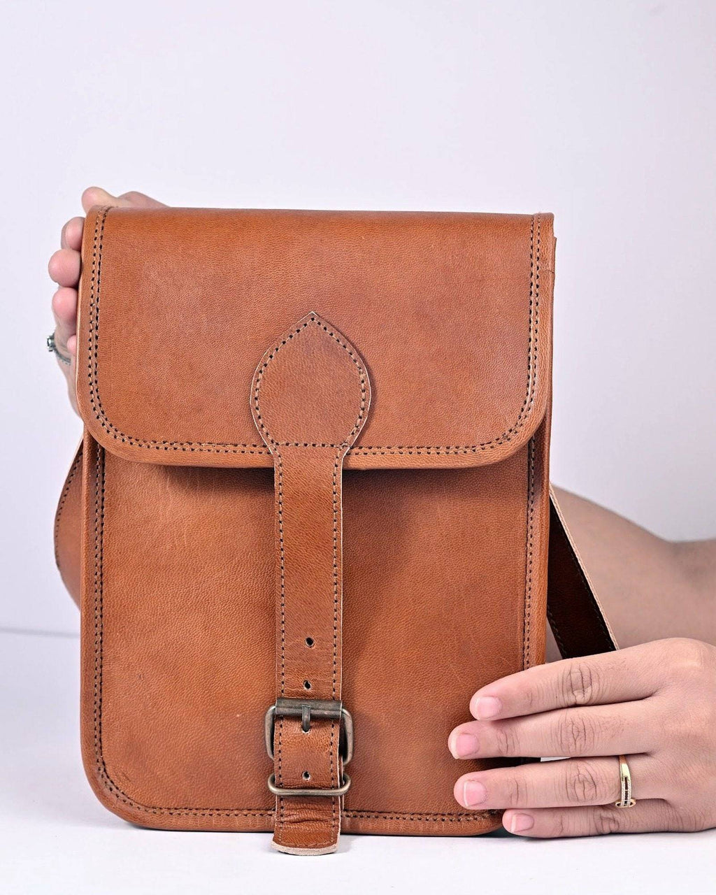 The Amer Sling held in hand — tall slim everyday scale